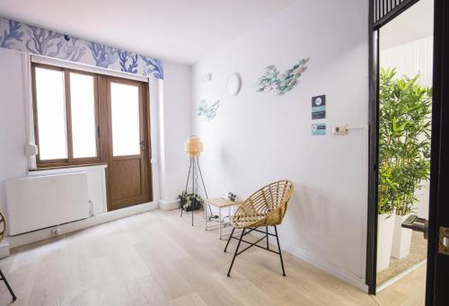 Zimmer mit einer Tür, einem Stuhl und einem Tisch in der Unterkunft Alda Coruñamar in A Coruña
