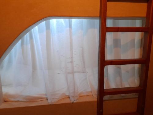 a window with a white curtain and a ladder at Private Room in Apartment TOV in Taghazout