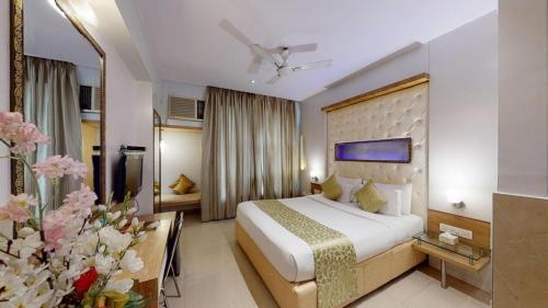 una camera d'albergo con un grande letto e fiori di Vihang's Inn a Thane