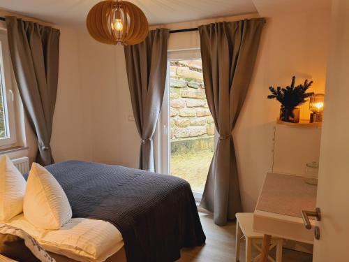 a bedroom with a bed in front of a window at FeWo Suhl-Heinrichs, 2 Schlafzimmer, 2 Terrassen in Suhl