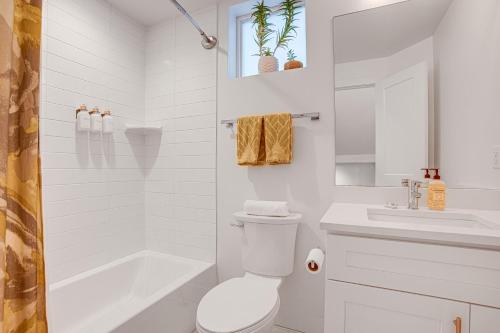baño blanco con bañera, aseo y lavamanos en Modern Denver Vacation Rental with Rooftop Deck! en Denver