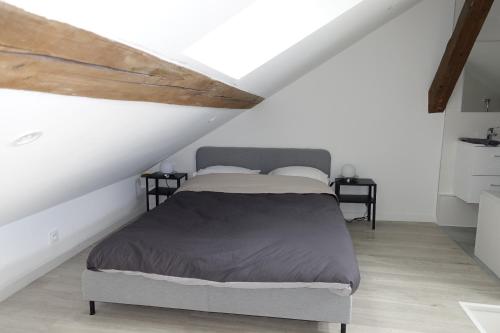 une chambre avec un lit dans un grenier dans l'établissement Dijon : Superbe appartement hyper centre en duplex, à Dijon