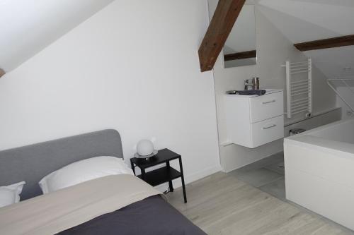 - une chambre avec un lit et une petite table de nuit dans l'établissement Dijon : Superbe appartement hyper centre en duplex, à Dijon