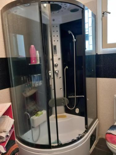 La salle de bains est pourvue d'une douche avec une porte en verre. dans l'établissement appartement cosy et chaleureux, à Rabat