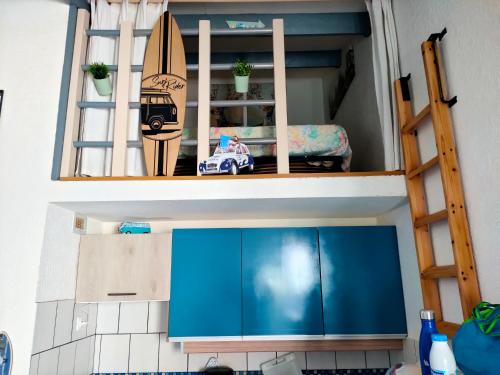 une maison de poupée avec une cuisine et une planche de surf dans l'établissement saint cyprien plage, à Saint-Cyprien