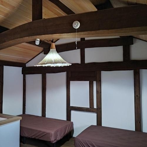 a room with two beds and a ceiling with a light at vacation house WAKURA わ蔵 in Tomi