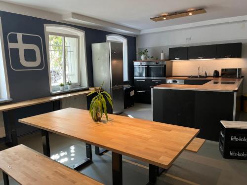 uma grande cozinha com uma mesa de madeira em Blue Doors Hostel Altstadt em Rostock