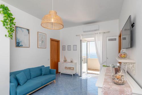Una sala de estar con un sofá azul y una mesa. en Villa Marea, en Praiano