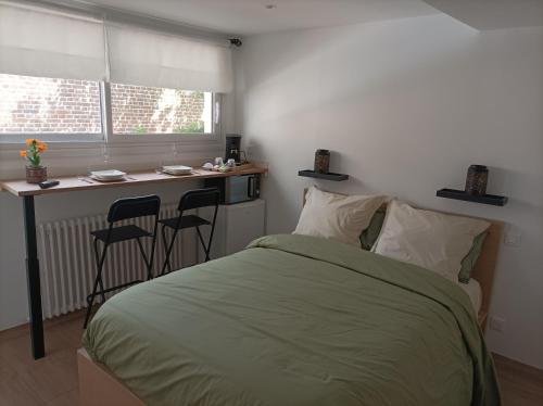 ein Schlafzimmer mit einem Bett und eine Küche mit einer Theke in der Unterkunft LE 16 CHAMBRES D'HÔTE in Friville-Escarbotin