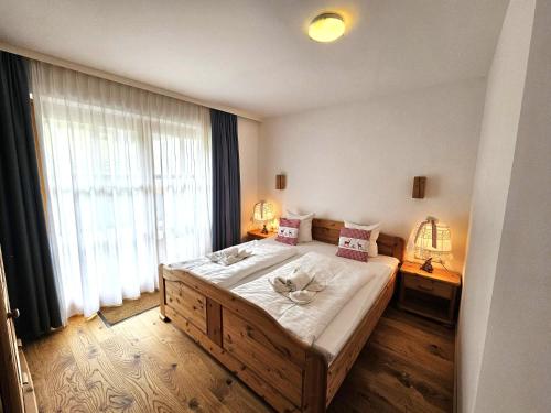 ein Schlafzimmer mit großem Bett und großem Fenster in der Unterkunft Deluxe Panorama Apartment-Maibrunn-Alm in Bad Kleinkirchheim