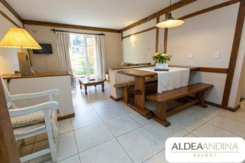 a living room with a table and a bench in a room at Alojamiento en Aldea Andina in San Carlos de Bariloche