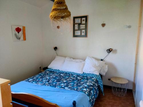 a bedroom with a bed with a blue comforter at saint cyprien plage in Saint-Cyprien
