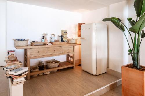 a kitchen with a refrigerator and a table with a plant at Zel Mallorca in Palmanova