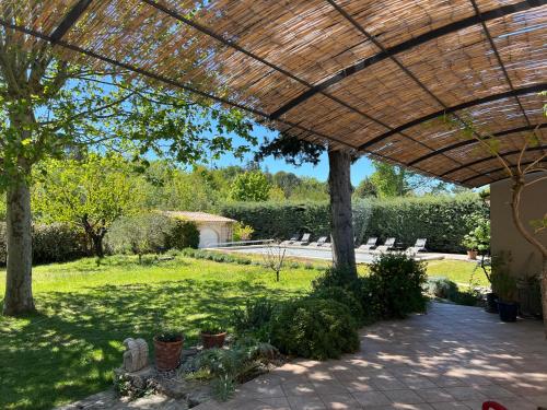 a view of a garden with a pergola at Les Cyprès in Lourmarin