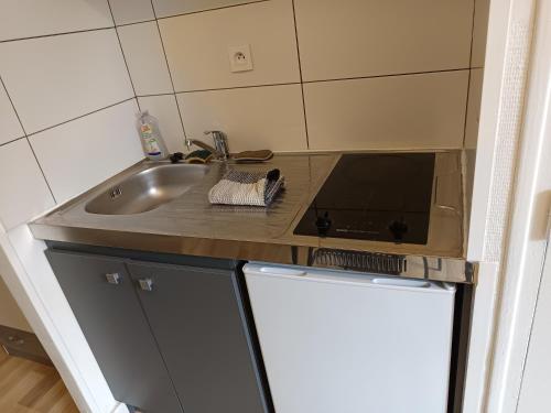 une cuisine avec un évier et un plan de travail dans l'établissement Studio vert tout équipé wifi, au Creusot