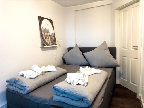 a couch with towels on top of it with a mirror at Messeapartment für 4 Gäste mit kostenlosen Parkplätzen in Hannover