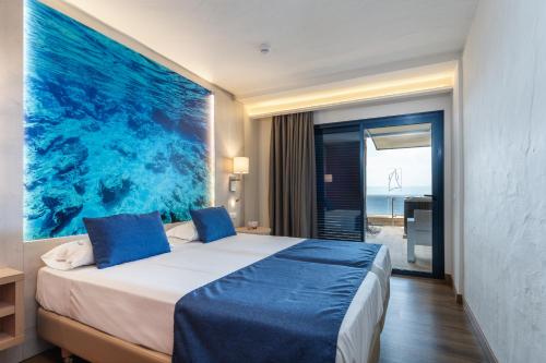 una camera da letto con un letto e un grande dipinto sul muro di Apartamentos Garden & Sea Boutique Lodging by LIVVO a Morro del Jable