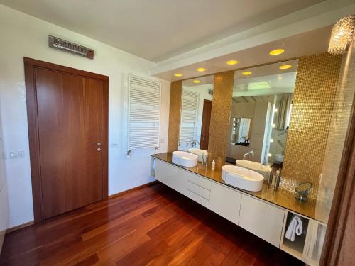 un bagno con due lavandini e un grande specchio di Villa Vanessa SUITES a Lugano