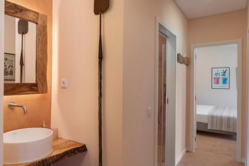 een badkamer met een wastafel en een spiegel bij Casas do Lanço by An Island Apart in São Vicente