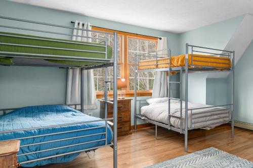 two bunk beds in a room with a window at 4 Lookout Point Road Plymouth Z Ocean House in Sandwich