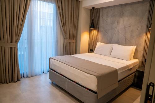 a bedroom with a bed and a large window at Bitez Adam Otel in Bodrum City