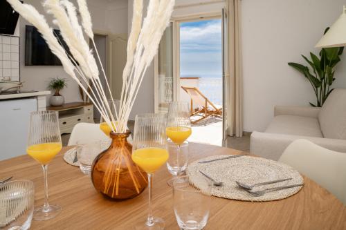 een tafel met vier glazen sinaasappelsap erop bij Maison Marì in Positano