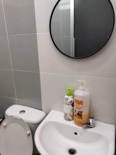 a bathroom with a toilet and a sink and a mirror at SAFI Homestay Perlis in Arau