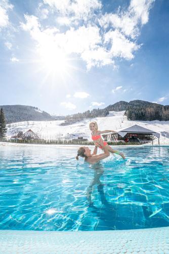 a woman is standing in a pool of water at Deluxe Panorama Apartment-Maibrunn-Alm in Bad Kleinkirchheim