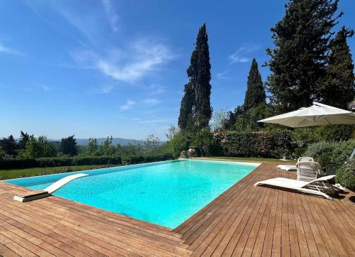 a swimming pool with two chairs and an umbrella at Semifonte Romantica in Petrognano