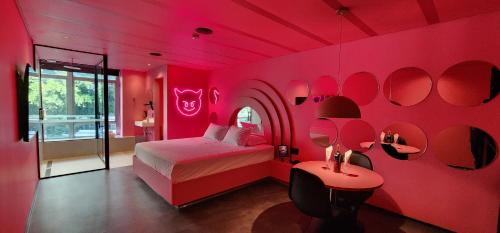 a bedroom with pink walls and a bed and a mirror at Andar de Cima Suítes in Sao Paulo