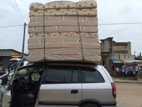 een auto met een stapel bagage erop bij Matelas PEB in Cotonou