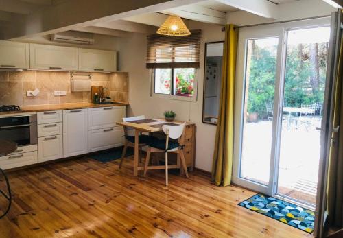 une cuisine avec une table et une grande fenêtre dans l'établissement les crins de la renardière, à Villeveyrac