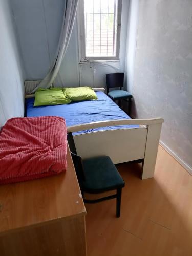1 dormitorio con 1 cama, 1 silla y 1 ventana en Hôtel familial de Saint-Georges, en Villeneuve-Saint-Georges