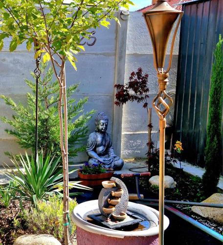 a statue of a buddha sitting in a garden at Penzión Florens, Nesvady in Nesvady