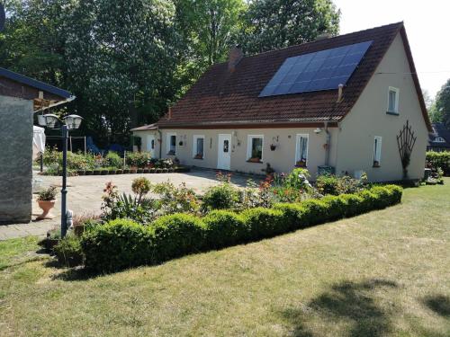 une maison avec un toit solaire et un jardin dans l'établissement Ferienwohnung "Am Stadtrand", à Garz