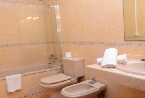 y baño con aseo, lavabo y ducha. en Apartamentos Trasmallo 1, en Playa Calera