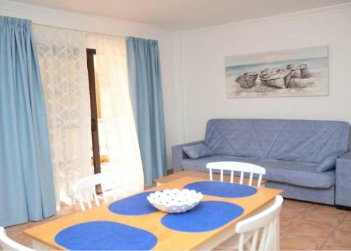 een woonkamer met een tafel en een blauwe bank bij Apartamentos Trasmallo 1 in La Playa Calera