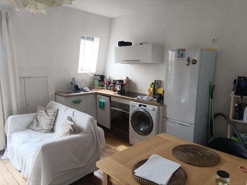 Il comprend une petite cuisine avec un canapé et un réfrigérateur. dans l'établissement Sunny apartment in Paris Batignolles, à Paris