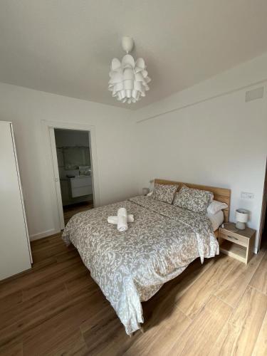 1 dormitorio con cama y lámpara de araña en Apartamento Oasis Mediterráneo, en San Vicente del Raspeig