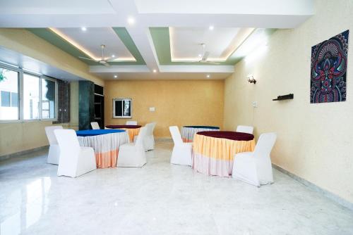 a meeting room with two tables and white chairs at Hotel The Galaxy in Dabok