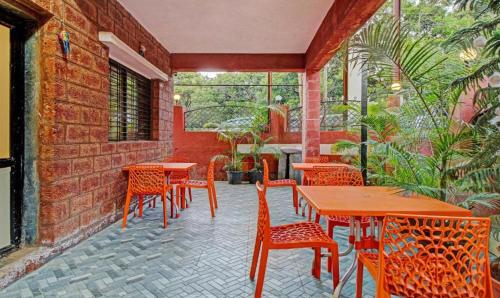 a patio with tables and chairs in a restaurant at Hotel Green Woods in Mahabaleshwar