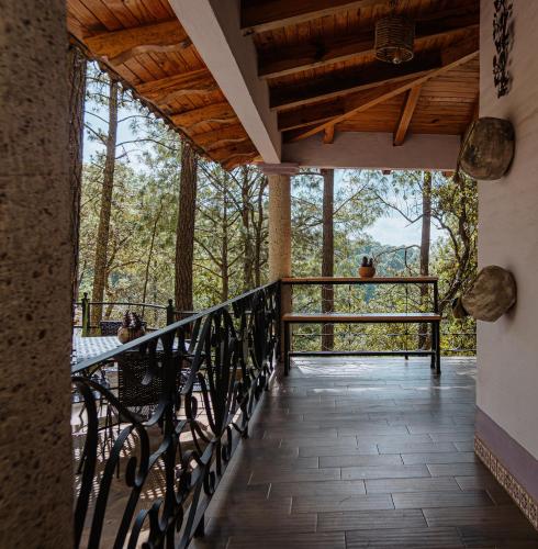 a balcony of a house with a view of the forest at BACANA CABAÑAS DE ALQUILER in Mazamitla
