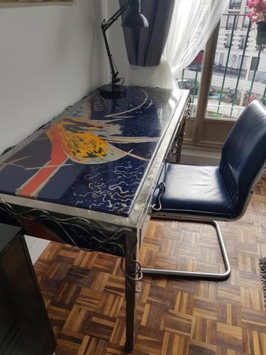 a table and a chair with a glass top at Studio 87 Avenue de Paris in Villejuif