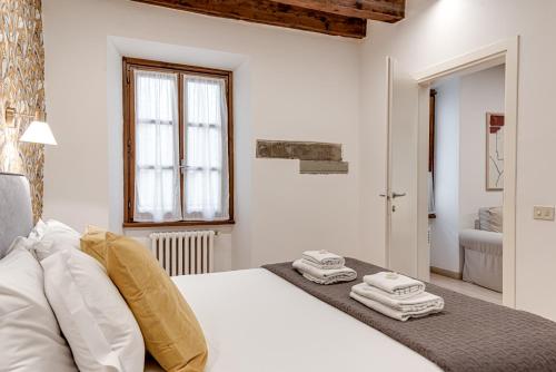 - une chambre blanche avec un lit et des serviettes dans l'établissement Tornabuoni City Center Florence, à Florence