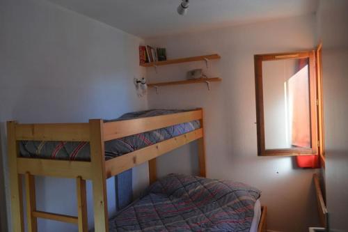 a bedroom with two bunk beds and a mirror at Appartement 7 couchages in Montvalezan