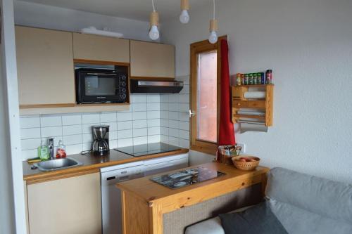 Appartement 7 couchages في Montvalezan: مطبخ صغير مع أريكة وقمة منضدة