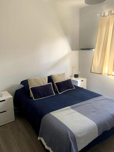 ein Schlafzimmer mit einem blauen Bett mit zwei Kissen in der Unterkunft Casa de Praia Quiaios in Quiaios