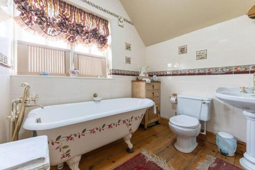 łazienka z wanną, toaletą i umywalką w obiekcie Beautiful country cottage for 8 - great staycation w mieście Wolverhampton