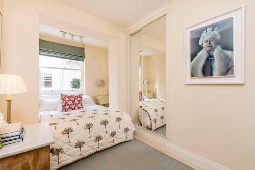 ein Schlafzimmer mit einem Spiegel, einem Bett und einem Sofa in der Unterkunft Delightful 2 Bed in Notting Hill - 5 min from tube in London