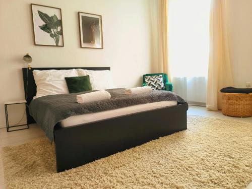 a bedroom with a black bed with a rug at CozyHome Signature Palisady Apartment in Bratislava